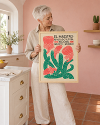 Lifestyle: kitchen — A Santa Barbara Spanish Revival house kitchen — arched plaster ceilings, Saltillo tile floor, white painted cabinets with aged brass hardware, and one long soft-blush-pink plaster wall.